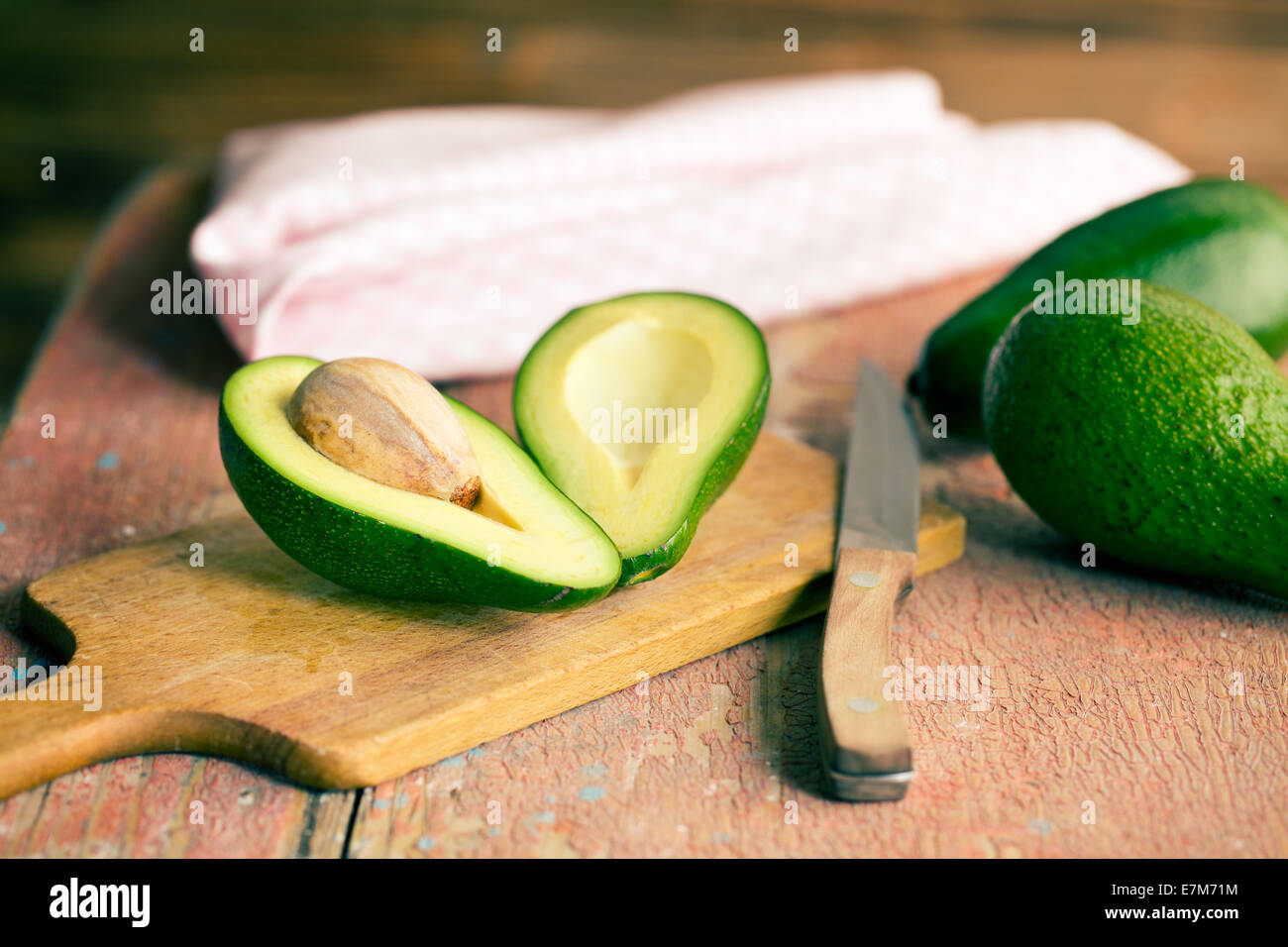 the halved avocados on old wooden table Stock Photo - Alamy
