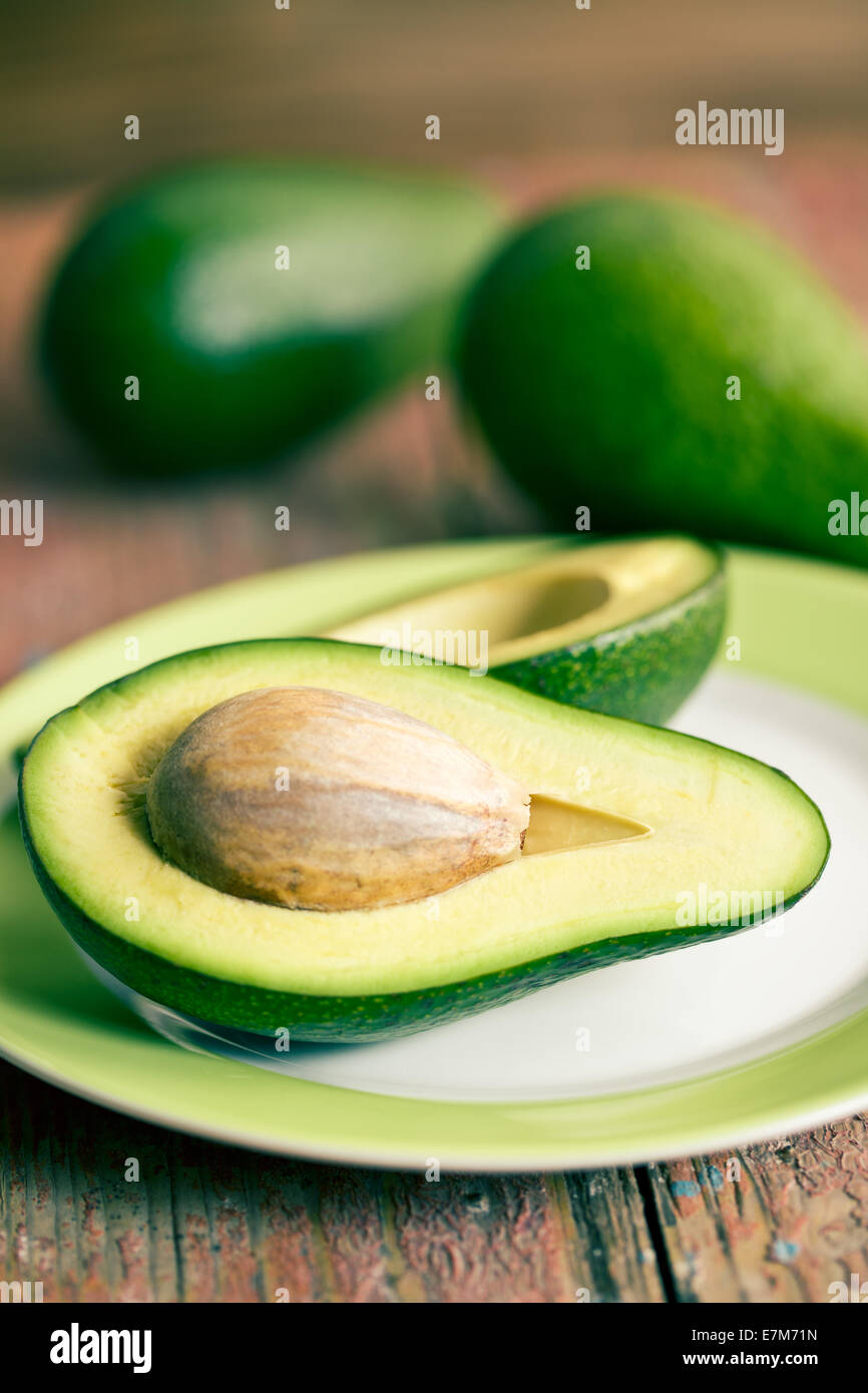 the halved avocados on old wooden table Stock Photo