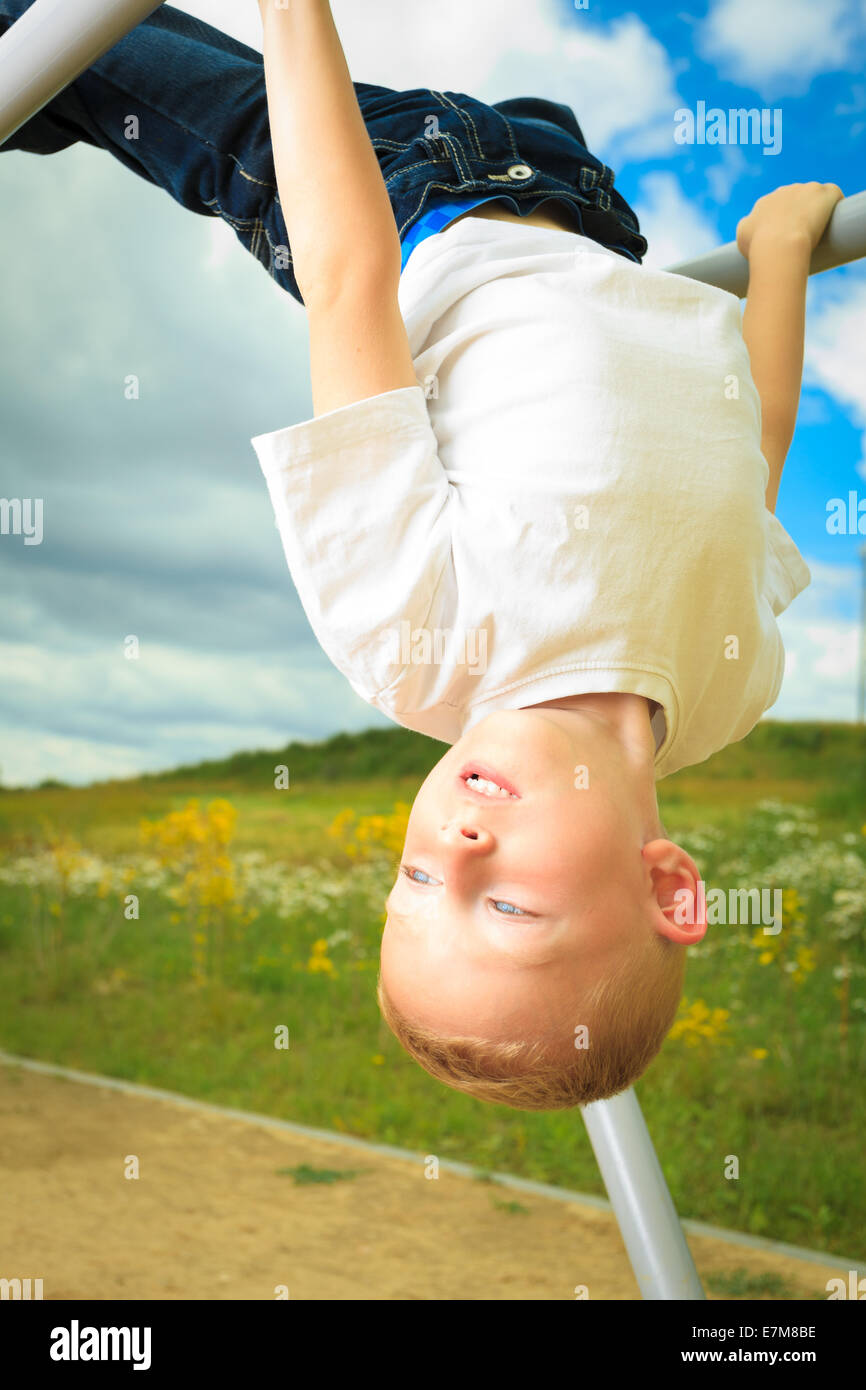 Child in playground in action boy playing on leisure equipment. Kid ...