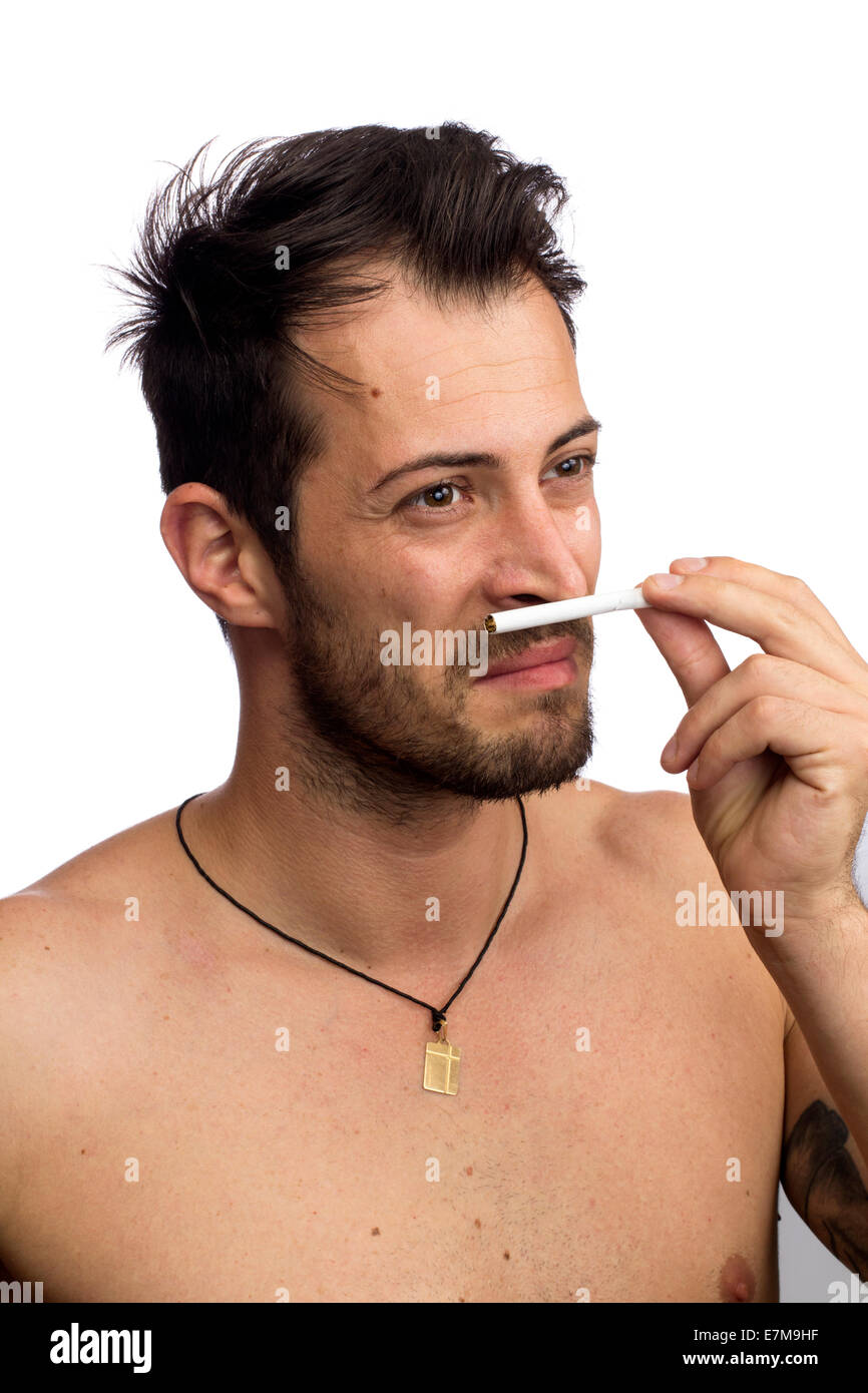 displeased young smelling a cigarette isolated over white background Stock Photo