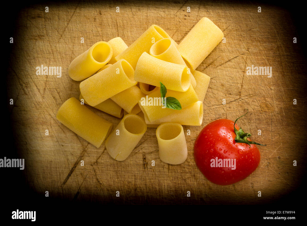 Paccheri pasta on wooden background with tomato Stock Photo