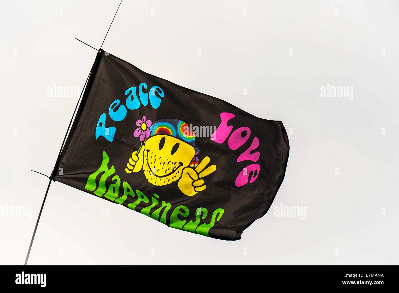 A Peace, Love and Happiness flag flying at the Brownstock Festival in Essex. Stock Photo