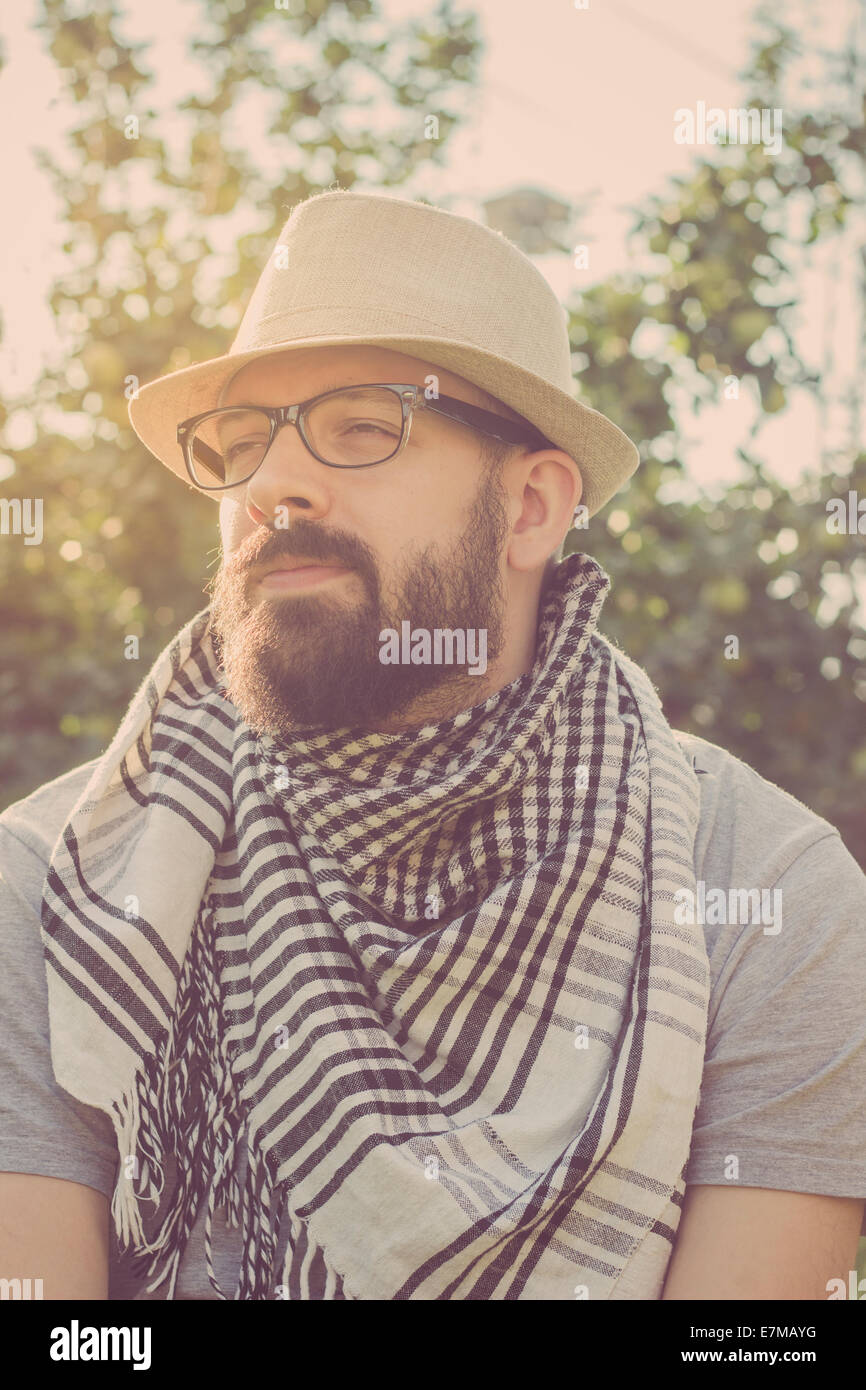 Portrait of a bearded young hipster man daydreaming, looking away. Retro tones Stock Photo