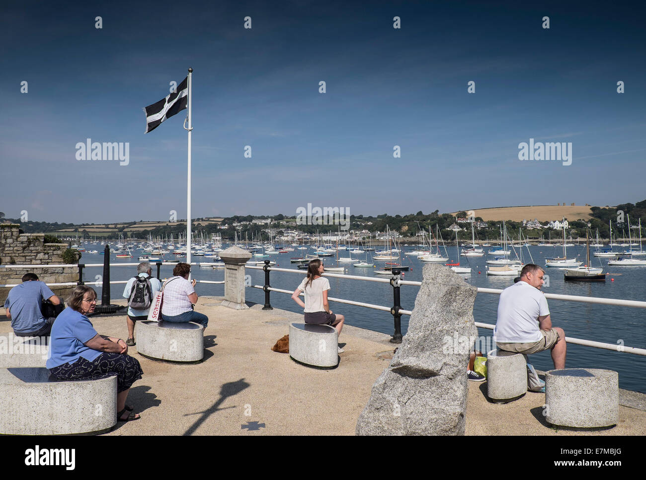 Holidaymakers relaxing on the St Nazaire Memorial on the Prince of Wales Pier in Falmouth. Stock Photo