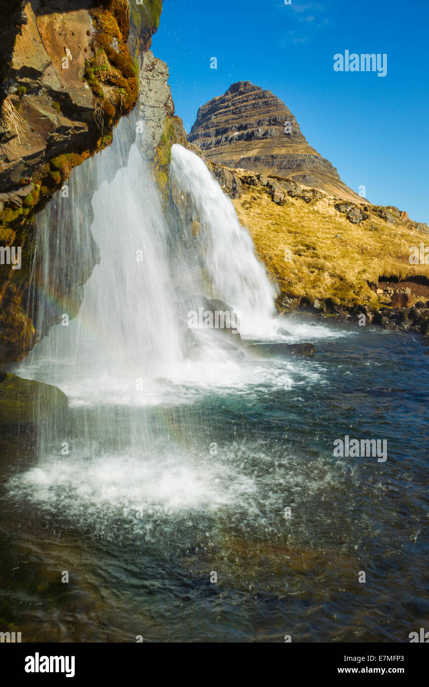 The Kirkjufell waterfall and mountain in daylight near Grundarfjordur bay, Snaefellsnes Peninsula, in western Iceland. Stock Photo