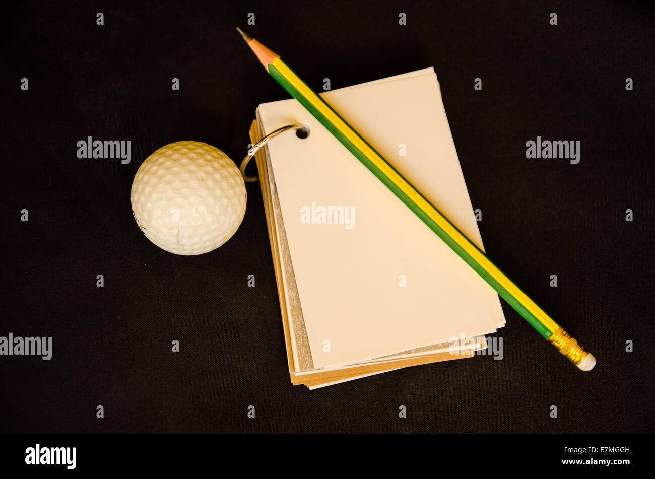 golf ball with notebook score card on black background Stock Photo