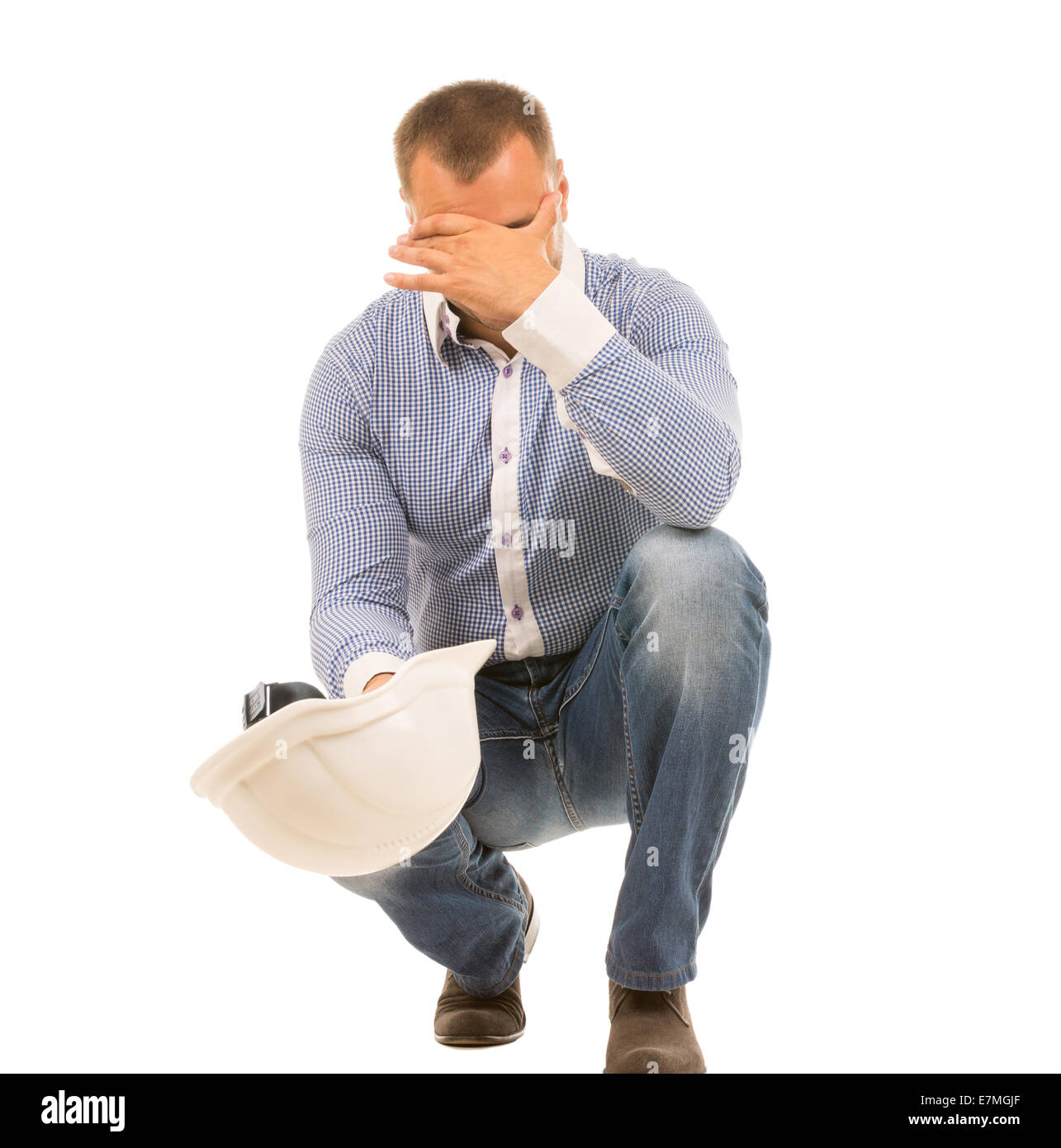 Crouching Man With Headache And Hard Hat Holding Head In Hand And Covering Eyes Stock Photo Alamy