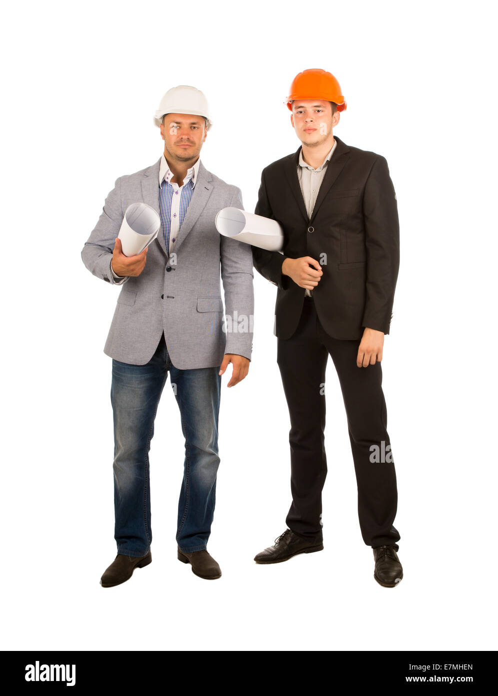 Middle Age Male Engineers, One is Wearing Gray Coat and Faded Blue Pants with White Helmet While Other is Wearing Black Suit and Stock Photo