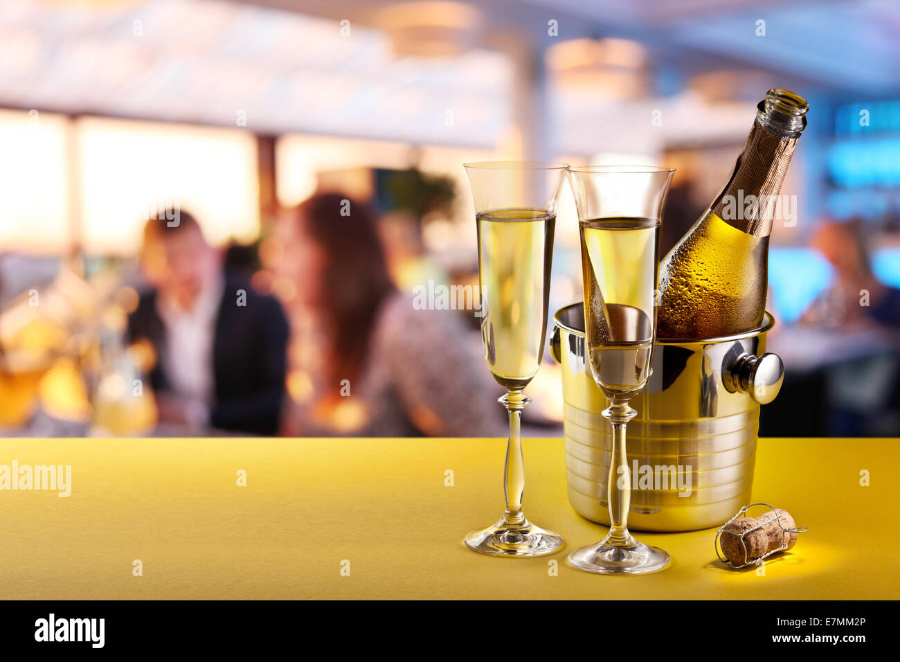 Champagne flutes and chilled bottle at the bar counter. Stock Photo