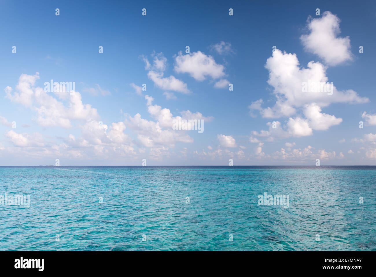 Tropical turquoise lagoon in  Indian Ocean. Bright blue sky with clouds. Used a polarizing filter Stock Photo