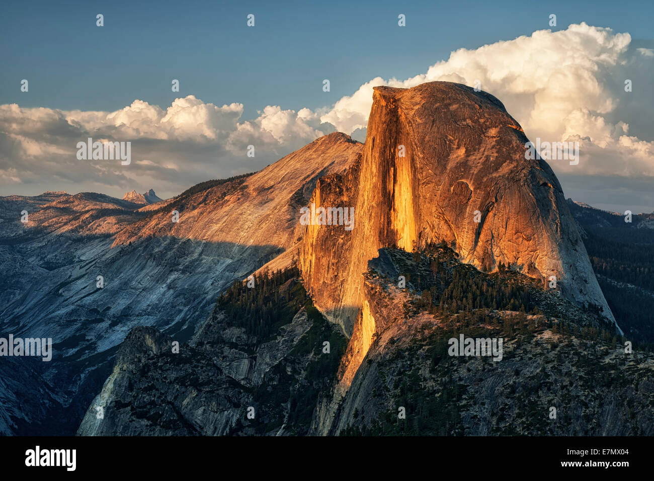 Evening's last light on the granite walls of Half Dome as thunderheads build over California's Yosemite National Park. Stock Photo