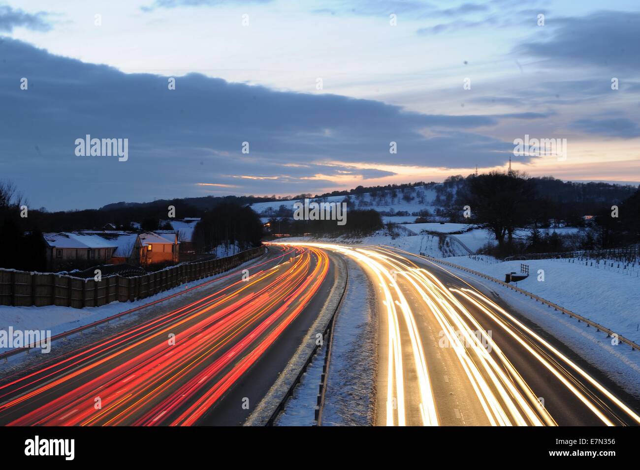 Heavy motorway traffic at rush hour at night on the M4 in the UK following snow fall. Stock Photo
