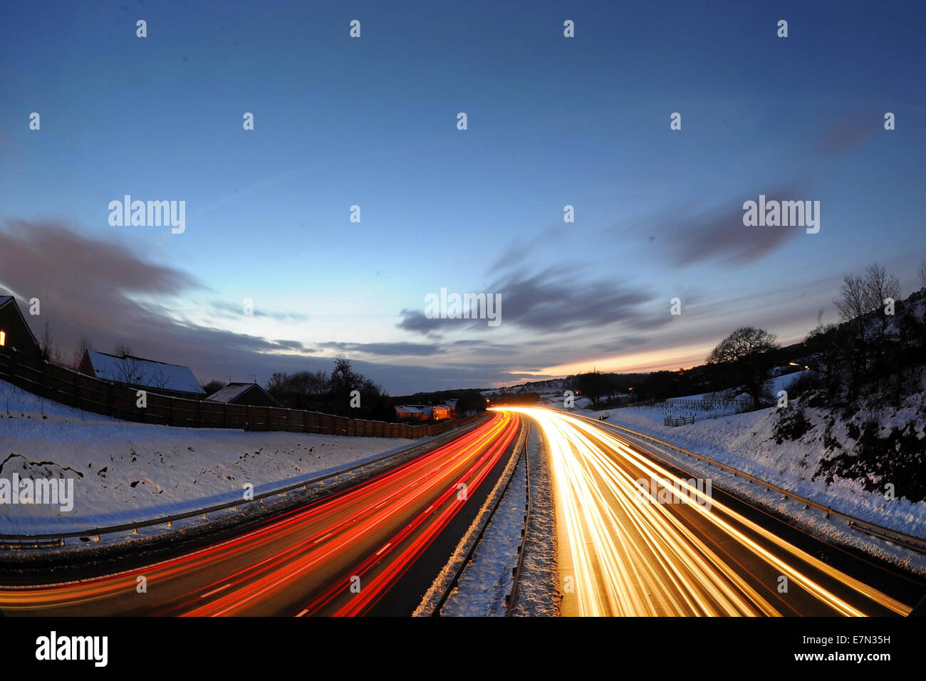 Heavy motorway traffic at rush hour at night on the M4 in the UK following snow fall. Stock Photo