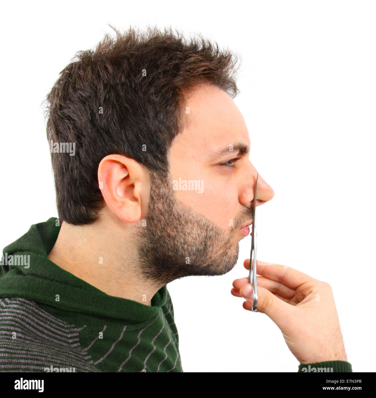 Concept of cosmetic surgery. Boy symbolically cutting the nose with scissors. Stock Photo