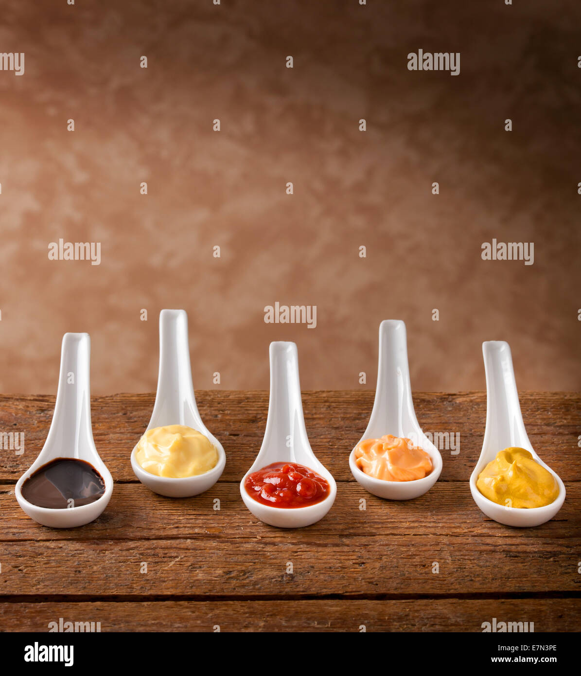 Sauces mixed in the ceramic spoons on wooden table Stock Photo Alamy