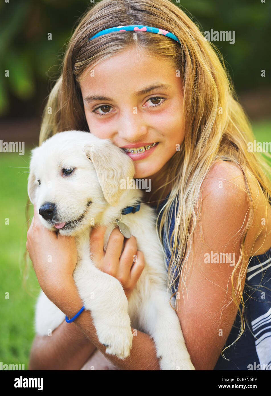 Adorable Cute Young Girl with Golden Retriever Puppy Stock Photo