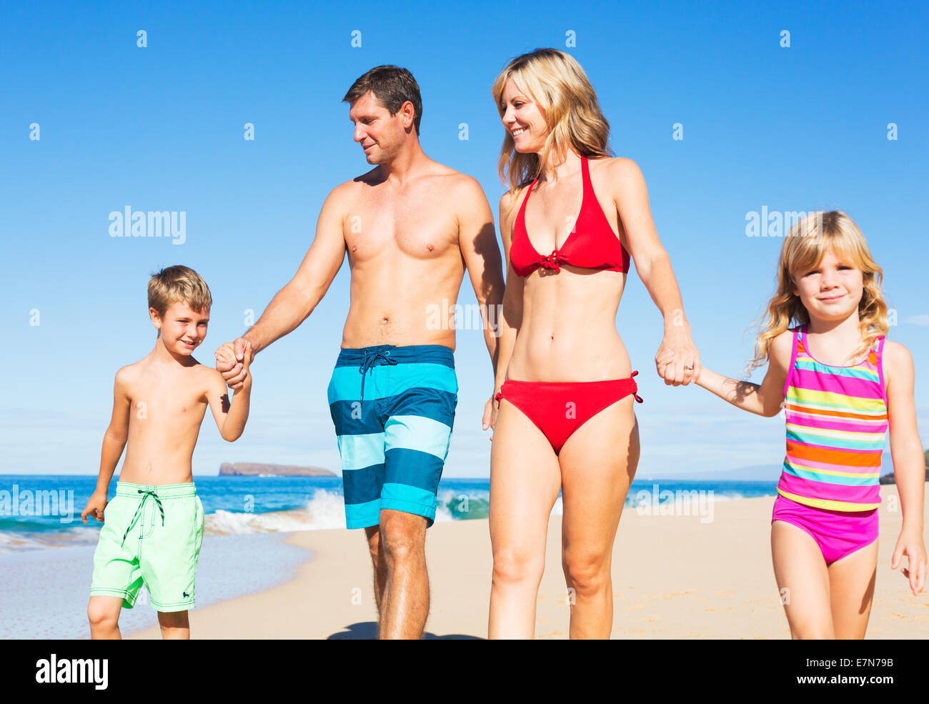 Happy Family of Four Having Fun at the Beach Stock Photo