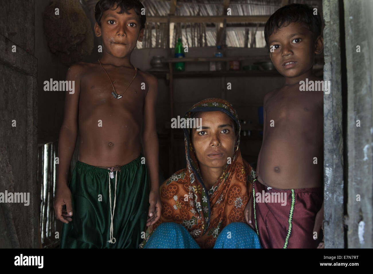 Oct. 18, 2012 - Hosneara (23) with her two sons, her husband Habibur Rahman (28) was killed by Tiger in the year 2009. Thousands of men and women go into the Sundarbans forest in Southern Bangladesh every day to gather honey, collect firewood, or catch fish, crabs and putting themselves at great risk for a tiger attack. In almost every village there is a woman or man, commonly the women are referred to as a 'Bagh Bidhoba'' that is ''Tiger Widow'', whose spouse has been a victim of a tiger attack. The men usually re-marry within a few months, but the women do not. As most women are wed when Stock Photo
