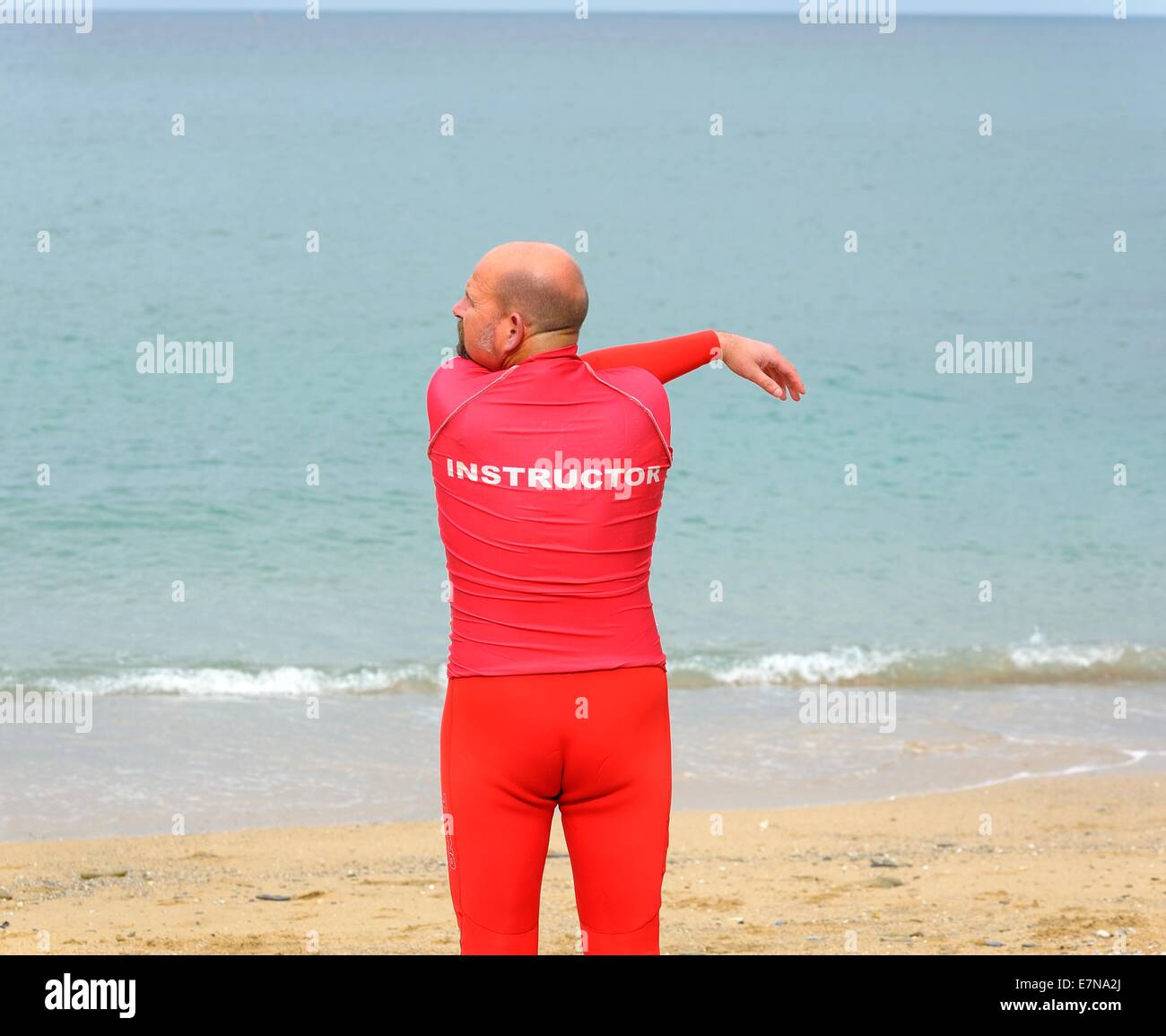 A surfing instructor doing warming up exercises Newquay Cornwall uk Stock Photo