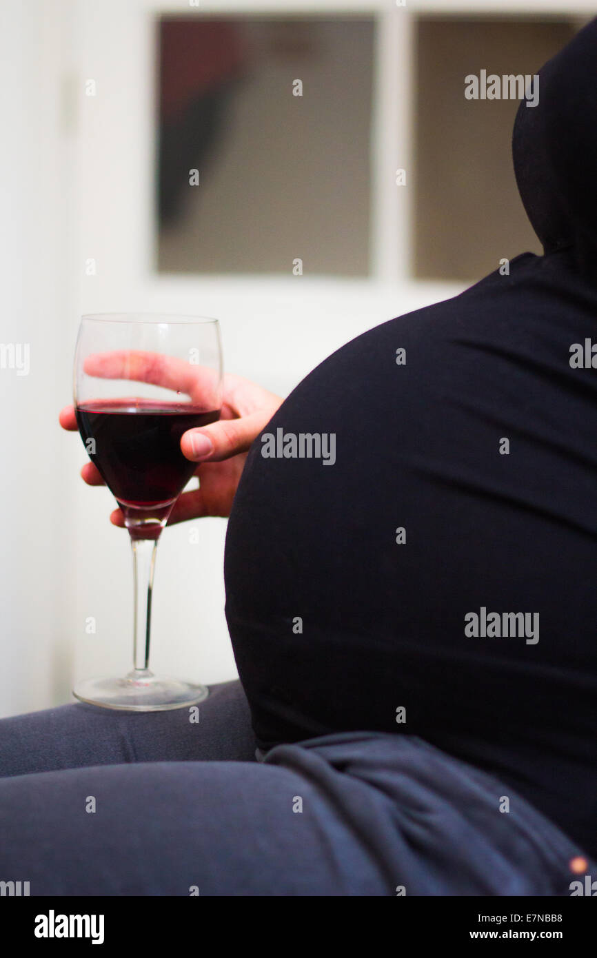 Pregnant woman holding a glass of wine Stock Photo