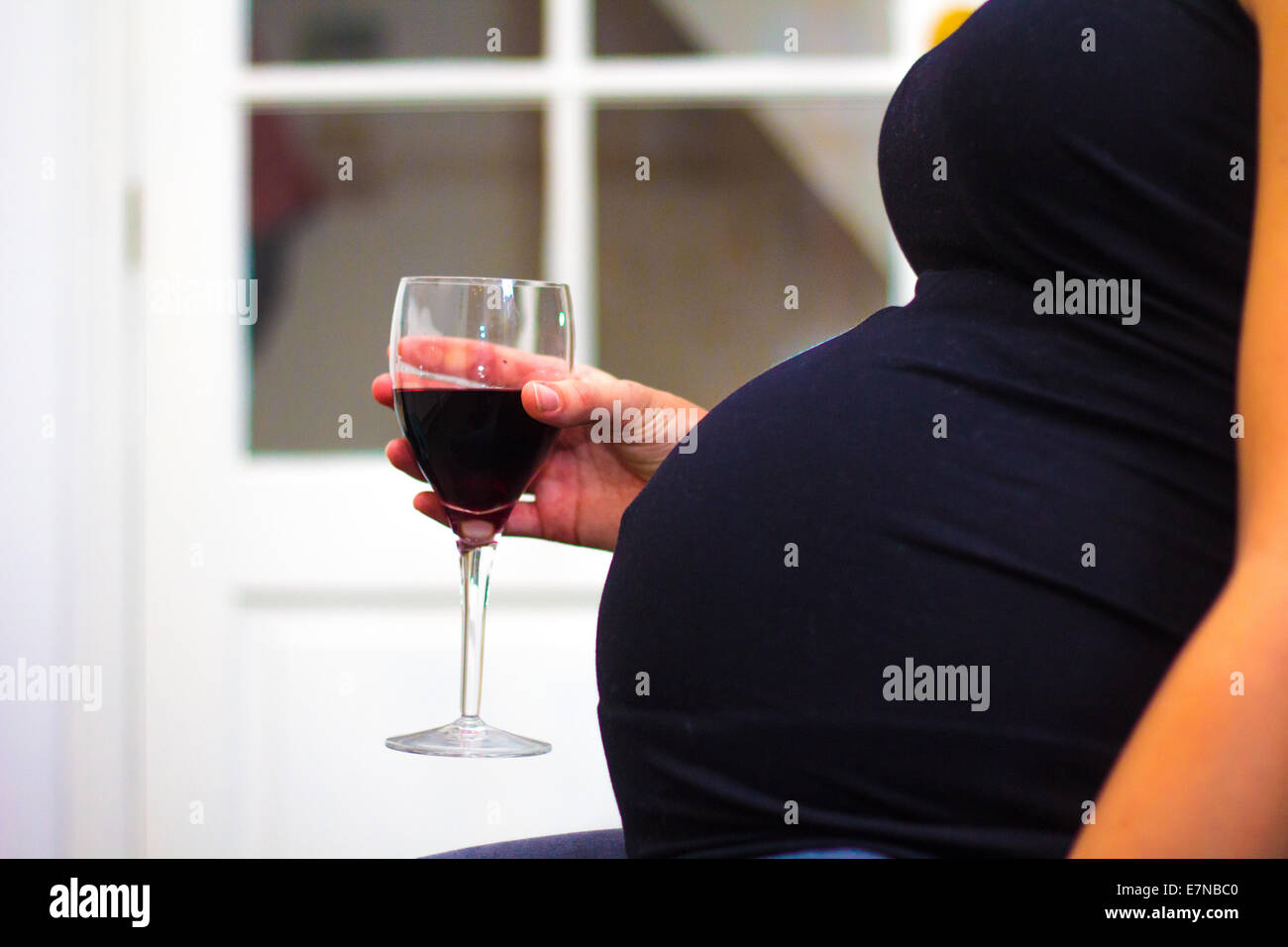 Pregnant woman holding a glass of wine Stock Photo