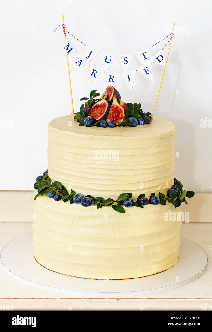 Rustic white wedding cake topped with fig and berries Stock Photo