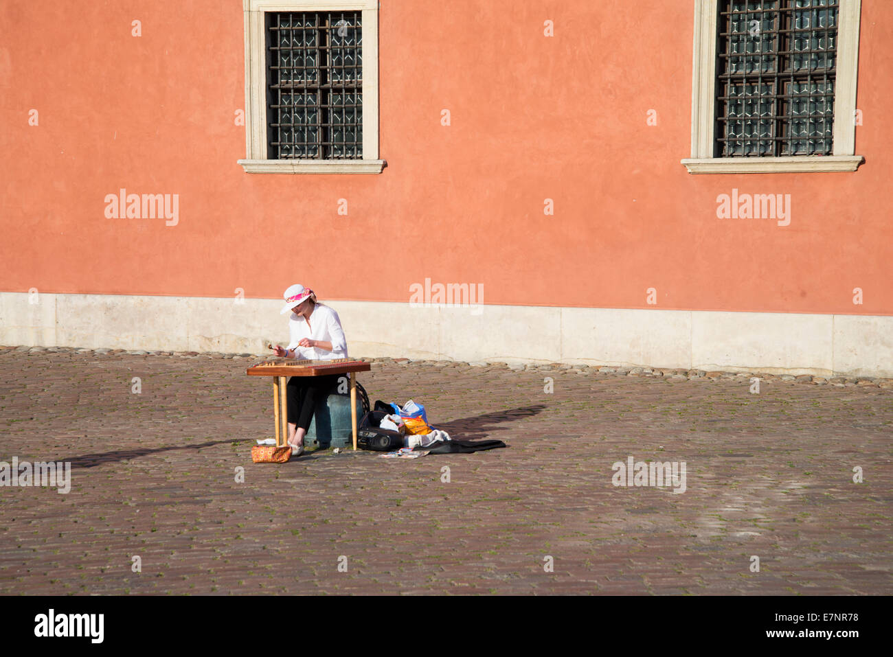 Warsaw, Poland, June 2014: Female street musician playing a hammered dulcimer in the old town Warsaw. Stock Photo