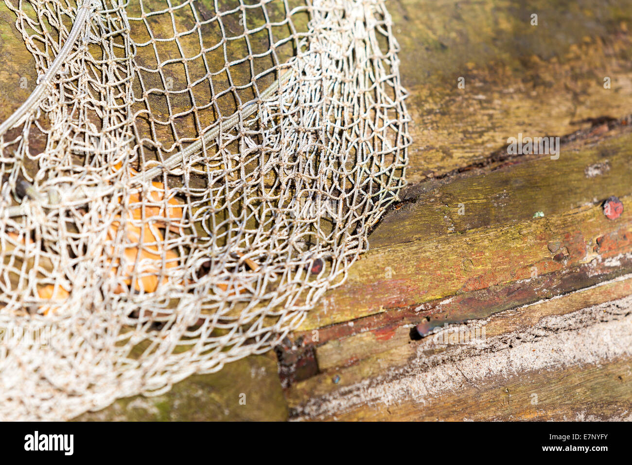 Fishing equipment. Closeup of old net. White fishnet on wooden