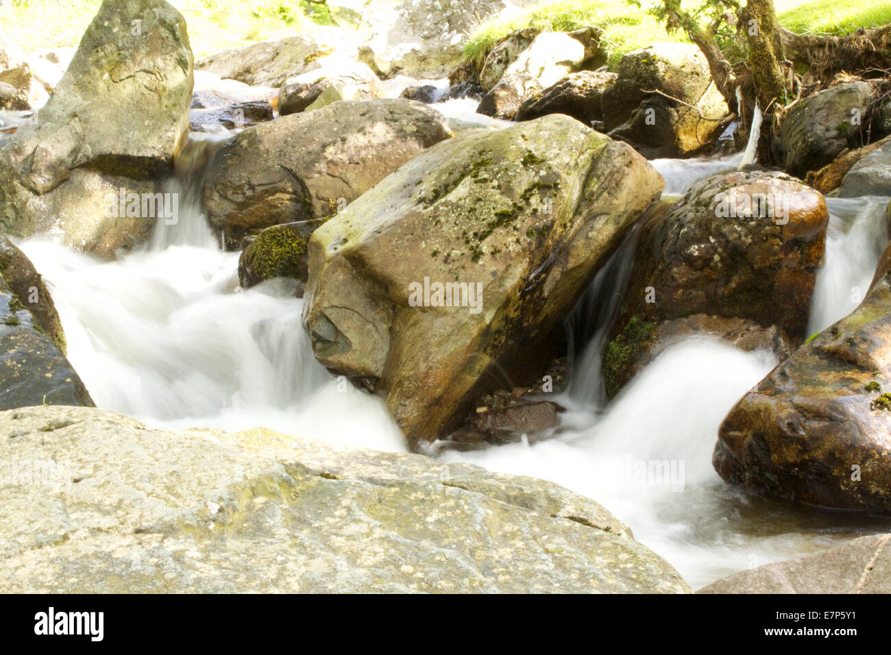 Fast flowing river over rocks showing a slow motion flow of the water. Stock Photo