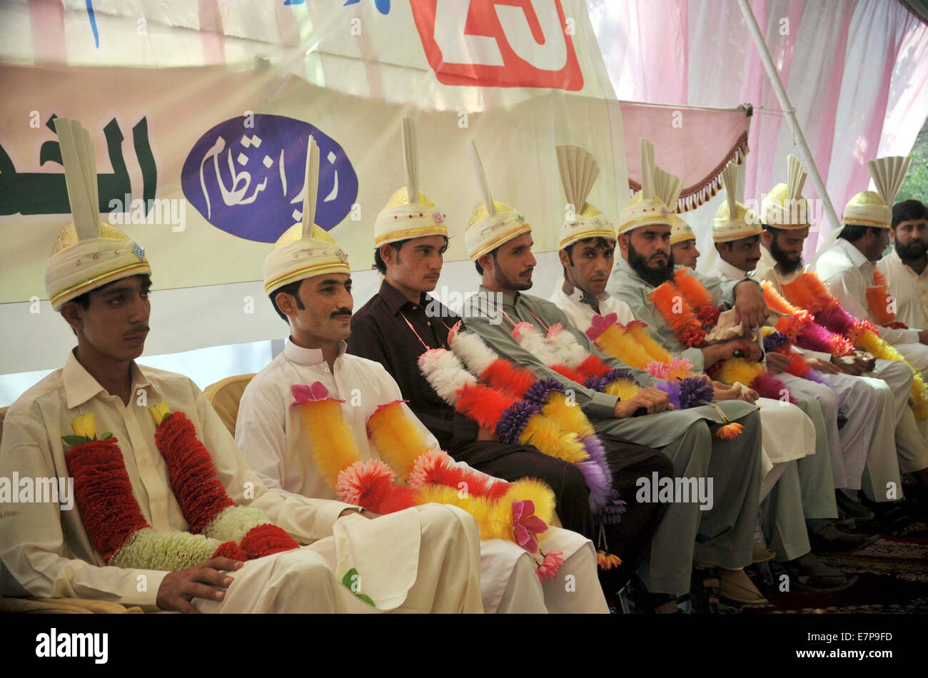 Group photo of bridegrooms during mass marriage ceremony organized by Jamat-e-Islami (JI) held at Markaz-e-Islami in Peshawar on Monday, September 22, 2014. Stock Photo