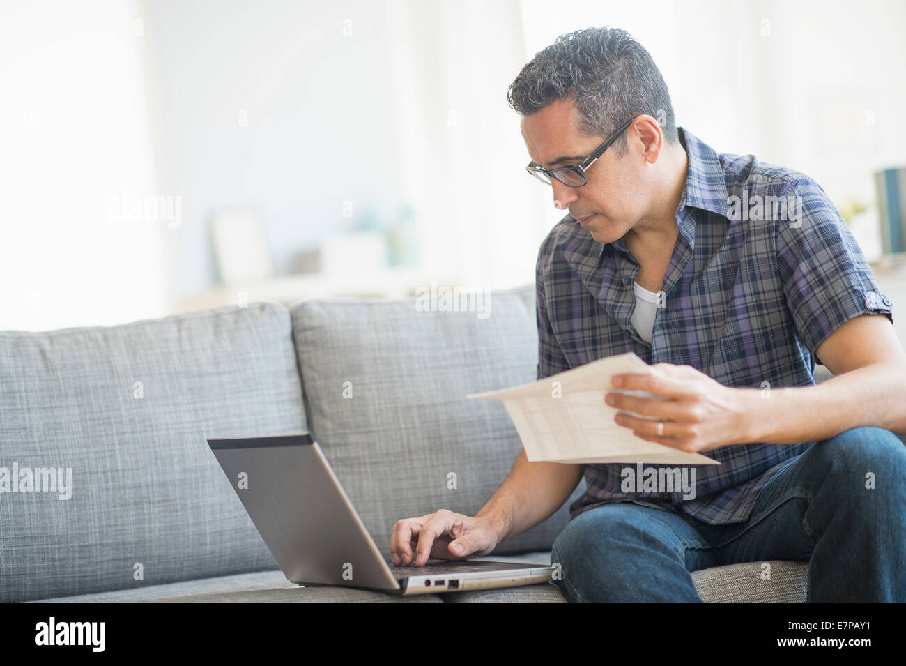 Man doing home finances with laptop Stock Photo