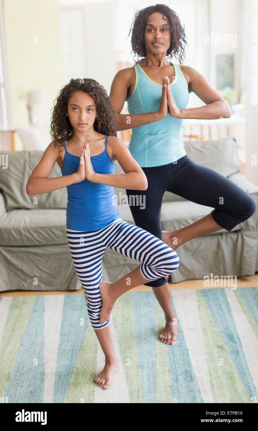 mother and daughter 8 9 doing in yoga poses in living room E7PB10