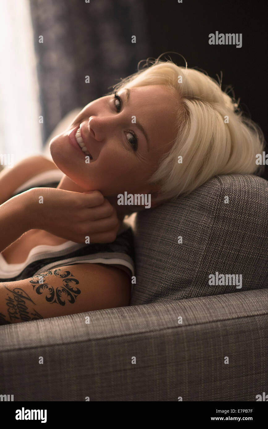 Portrait of blonde woman relaxing on sofa Stock Photo - Alamy