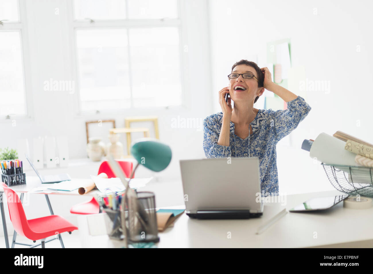 Senior business woman using cell phone in office Stock Photo