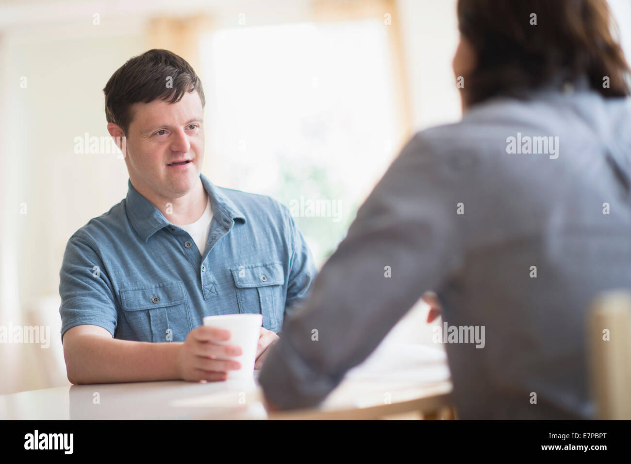 Man with down syndrome talking with care taker Stock Photo