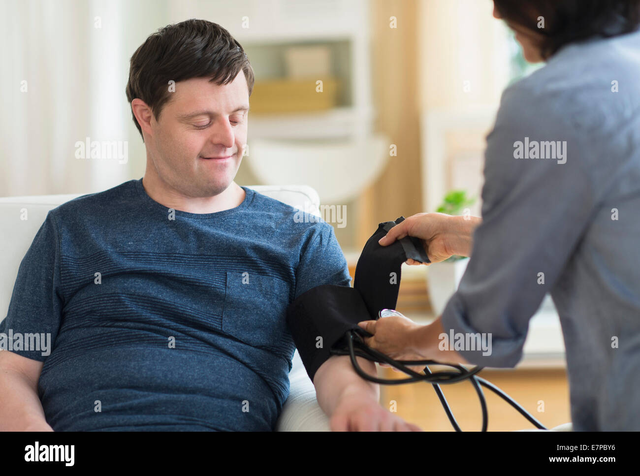 Man with down syndrome having blood pressure measured Stock Photo