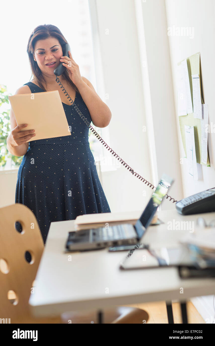 Woman using telephone in office Stock Photo