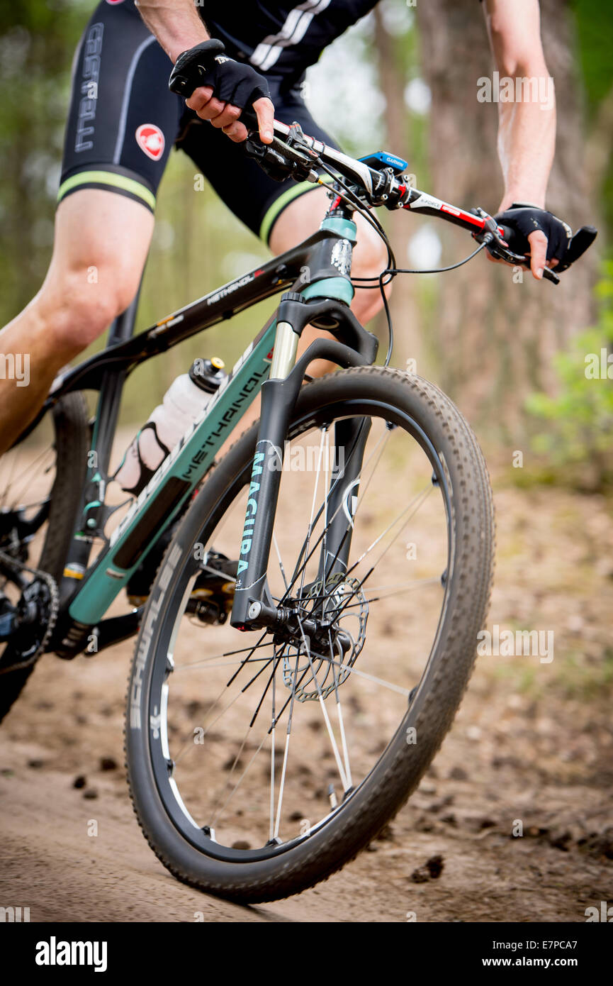 Closeup from a mountainbiker in the woods, details of the front part of the bike with his hands Stock Photo