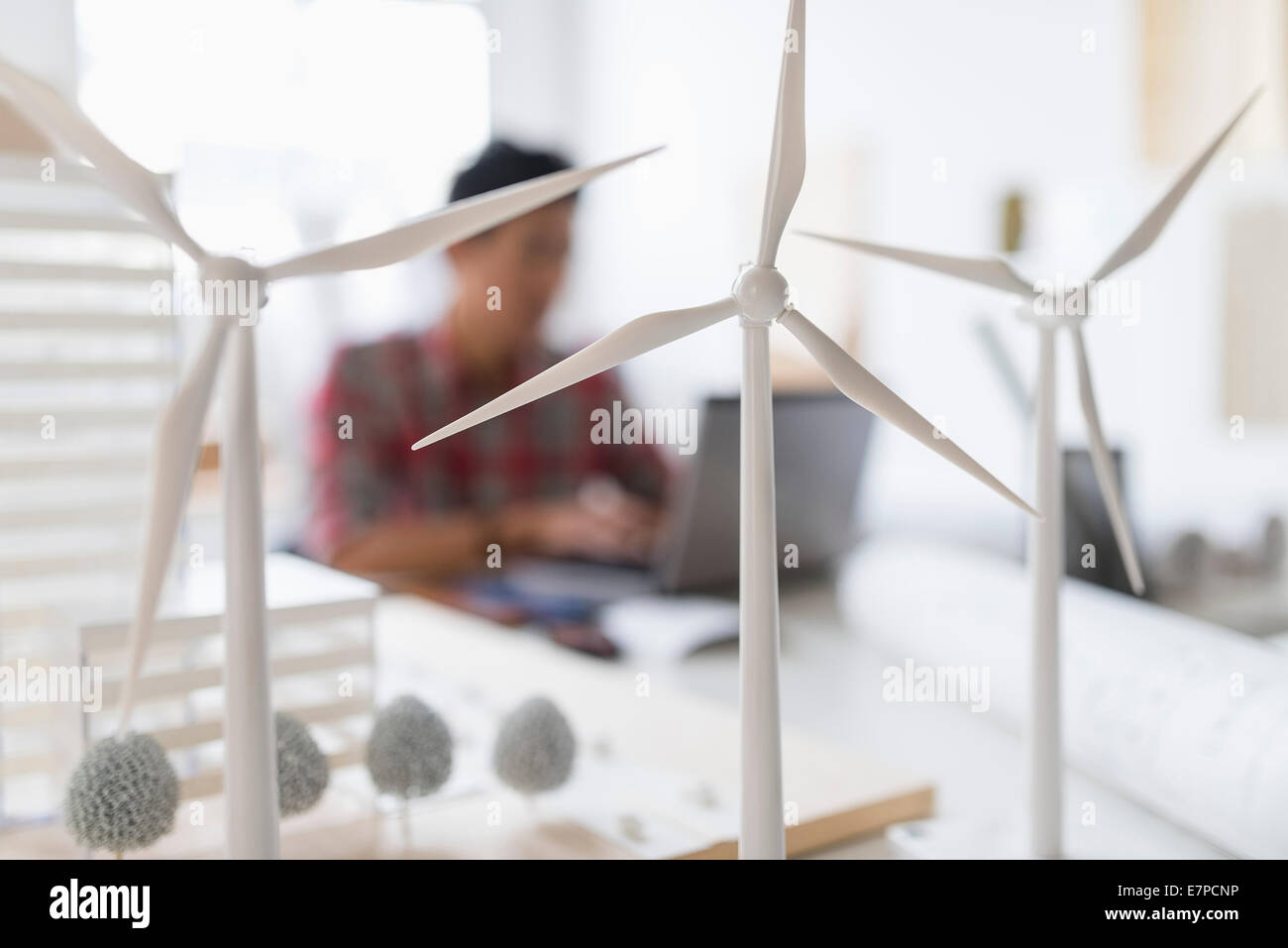 Wind turbine models on desk, architect in background Stock Photo