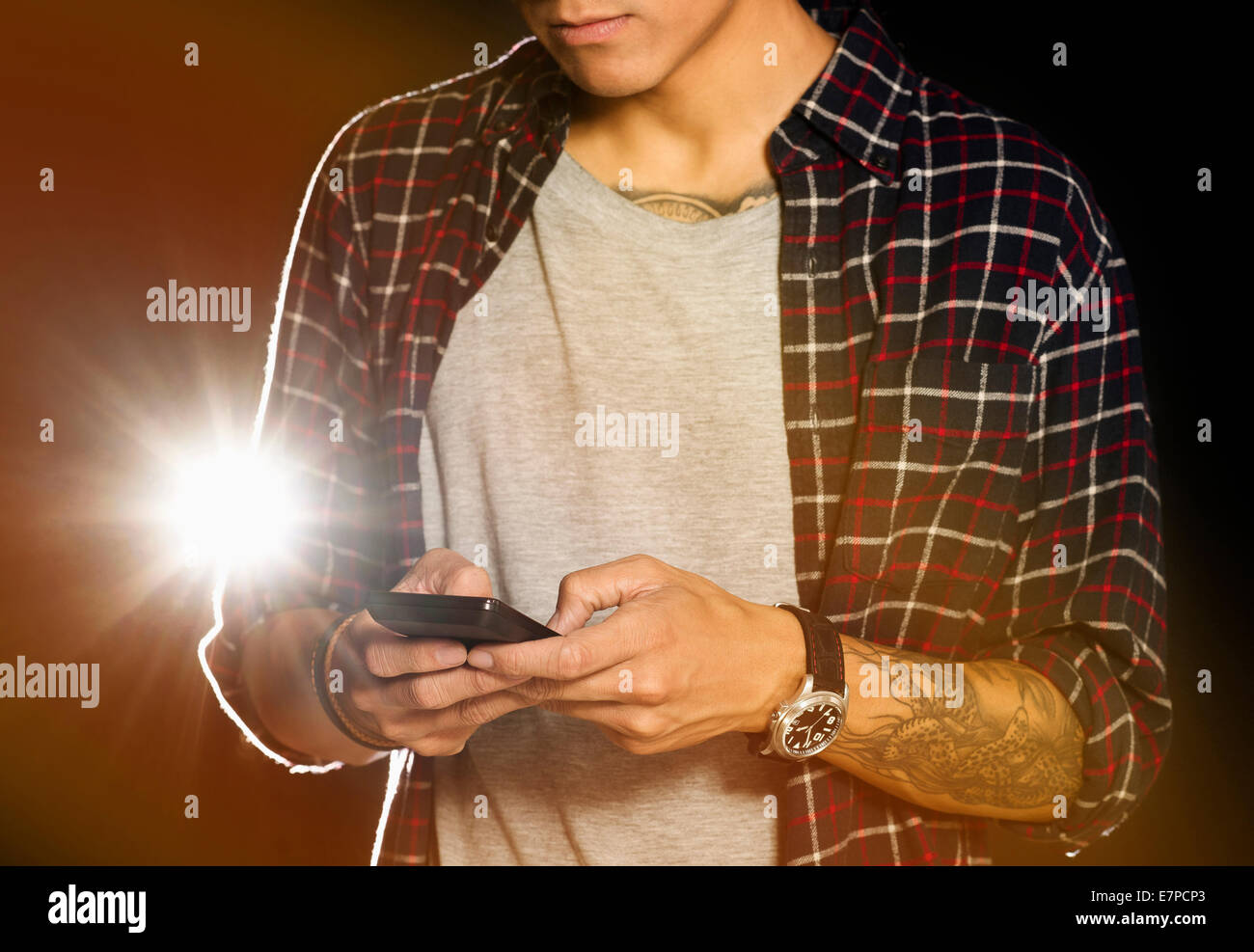Mid section of man text messaging at night Stock Photo