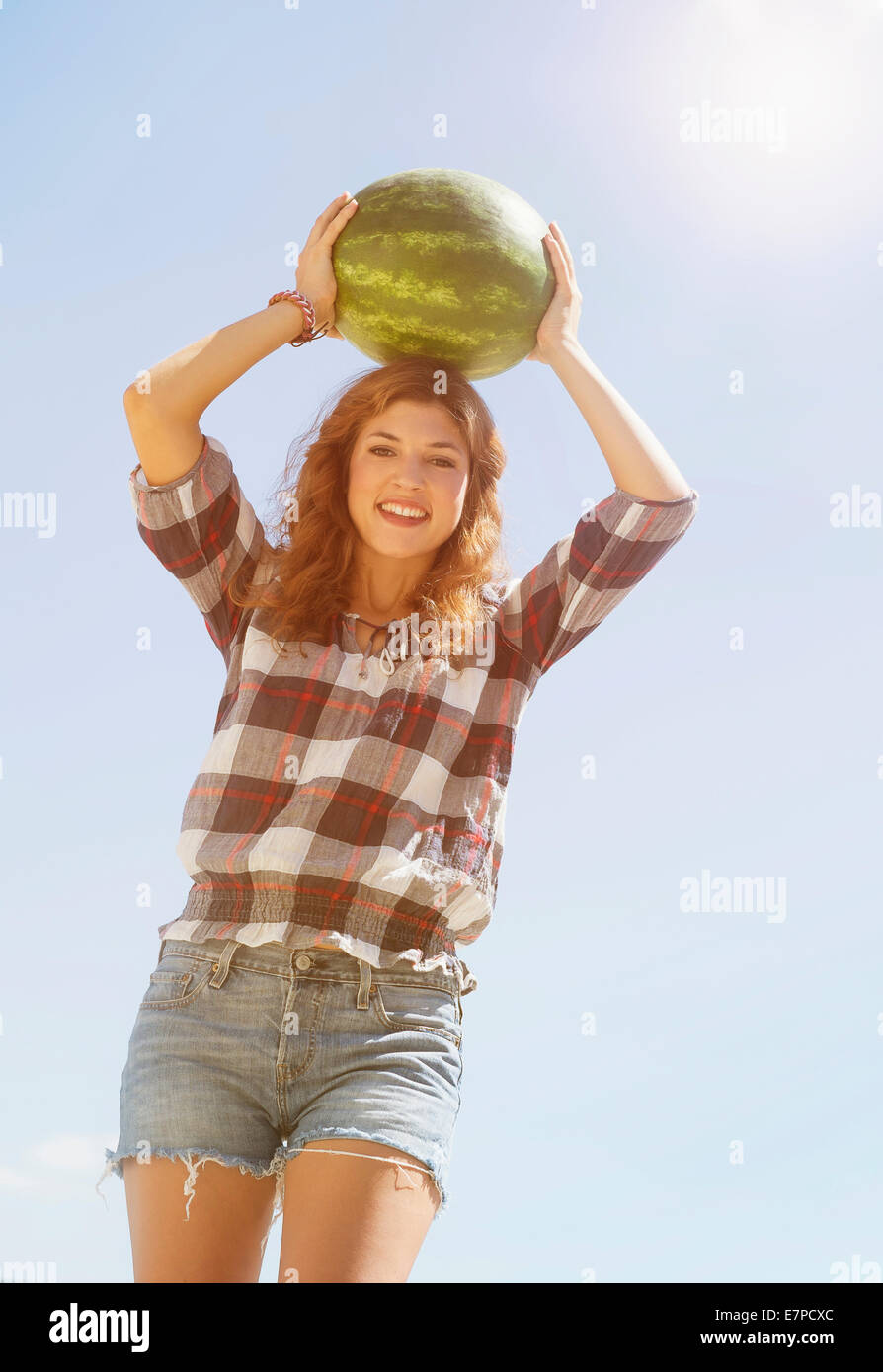 Young woman carrying on head watermelon Stock Photo