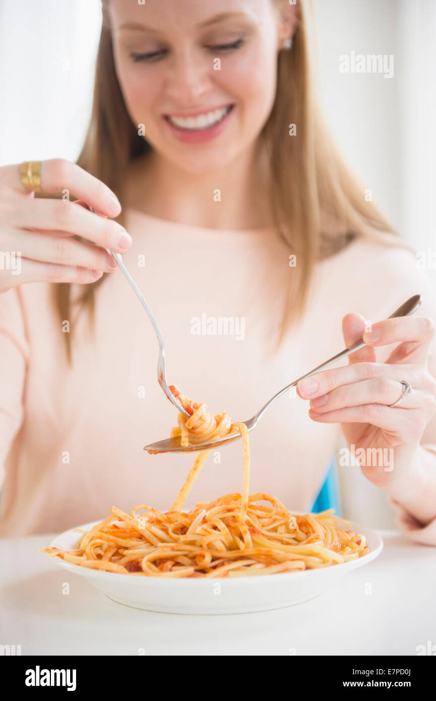 Young woman eating fettuccini Stock Photo