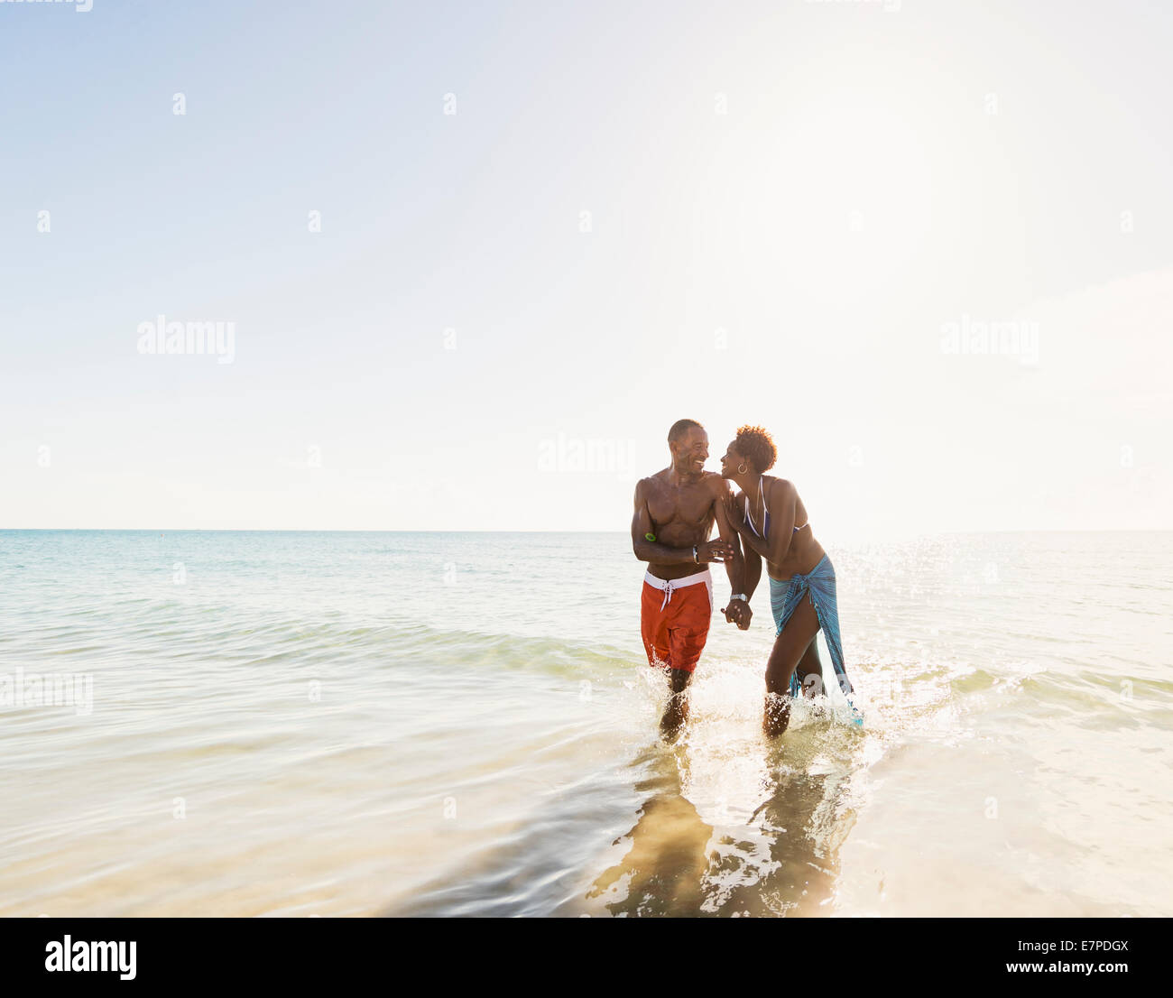 Man and woman holding hands on beach Stock Photo - Alamy