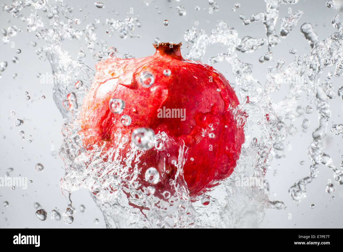 Droplets splashing on pomegranate Stock Photo