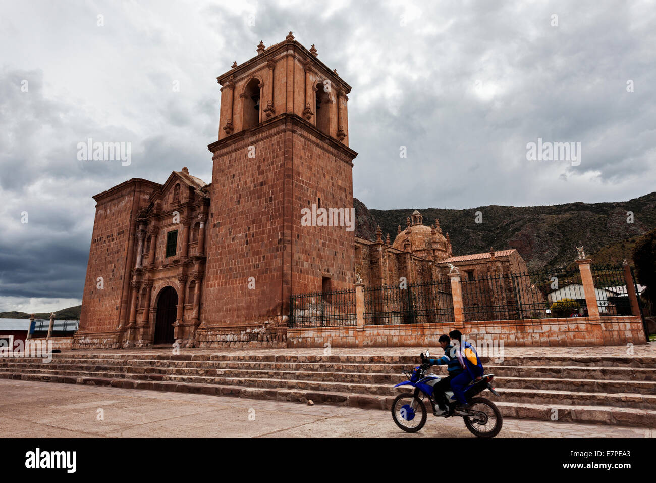 Peru, Arequipa, Two boys on motorcycle passing near old church Stock Photo