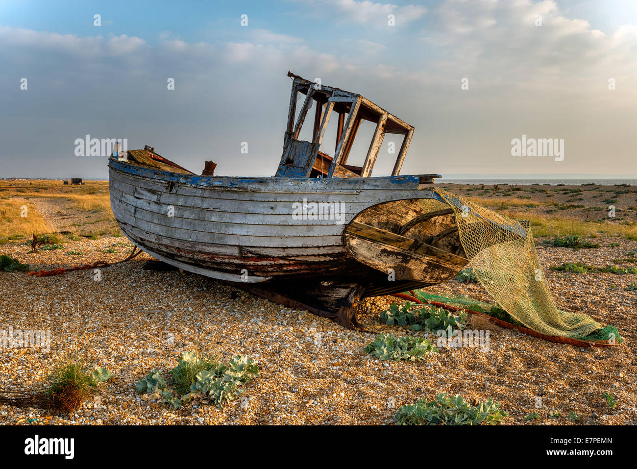 Old wooden fishing boat stranded on a shingle beach Stock Photo