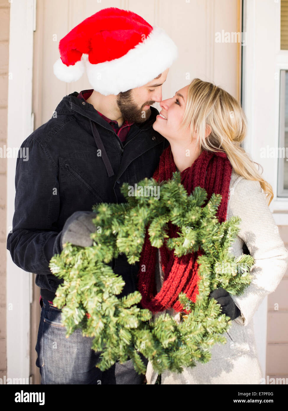 Young couple holding wreath, looking face to face Stock Photo