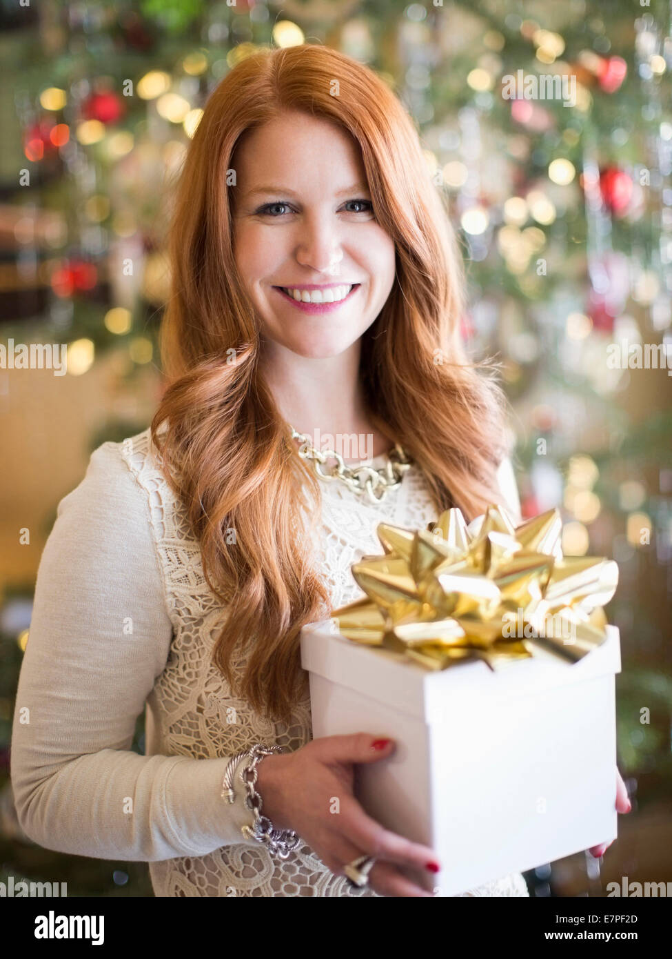 Studio shot of mid adult woman holding present in Christmas time Stock Photo