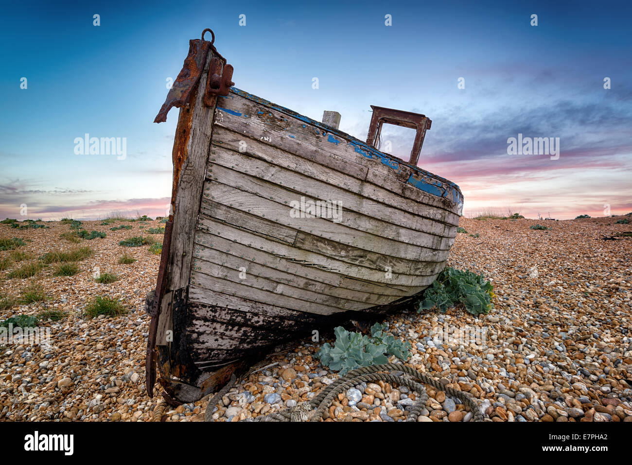 An old abandoned wooden fishing boat high on a shingle beach Stock ...