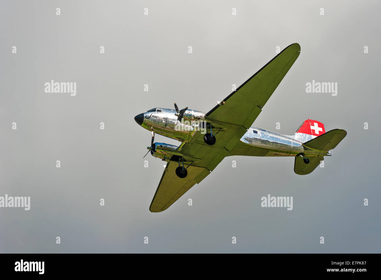 A Douglas DC-3 (Dakota) aircraft, of Swissair, coming in to land against a grey sky Stock Photo